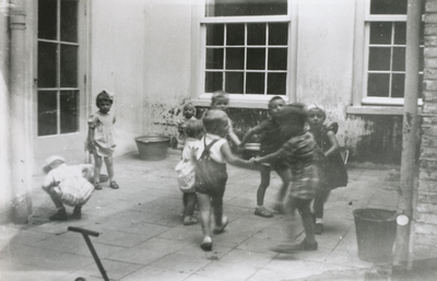 876985 Afbeelding van spelende kleuters op de binnenplaats van het opvanghuis 'Meisjesstad' (Oudegracht 35) aan de rand ...